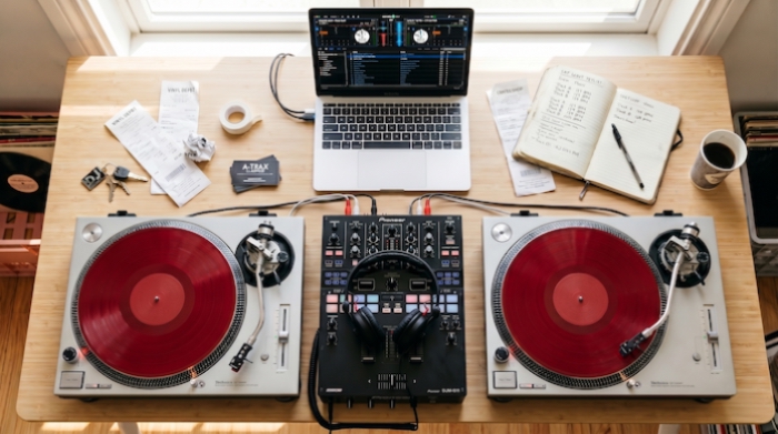 DJ setup with Serato laptop and receipts on a desk representing DJ tax write-offs