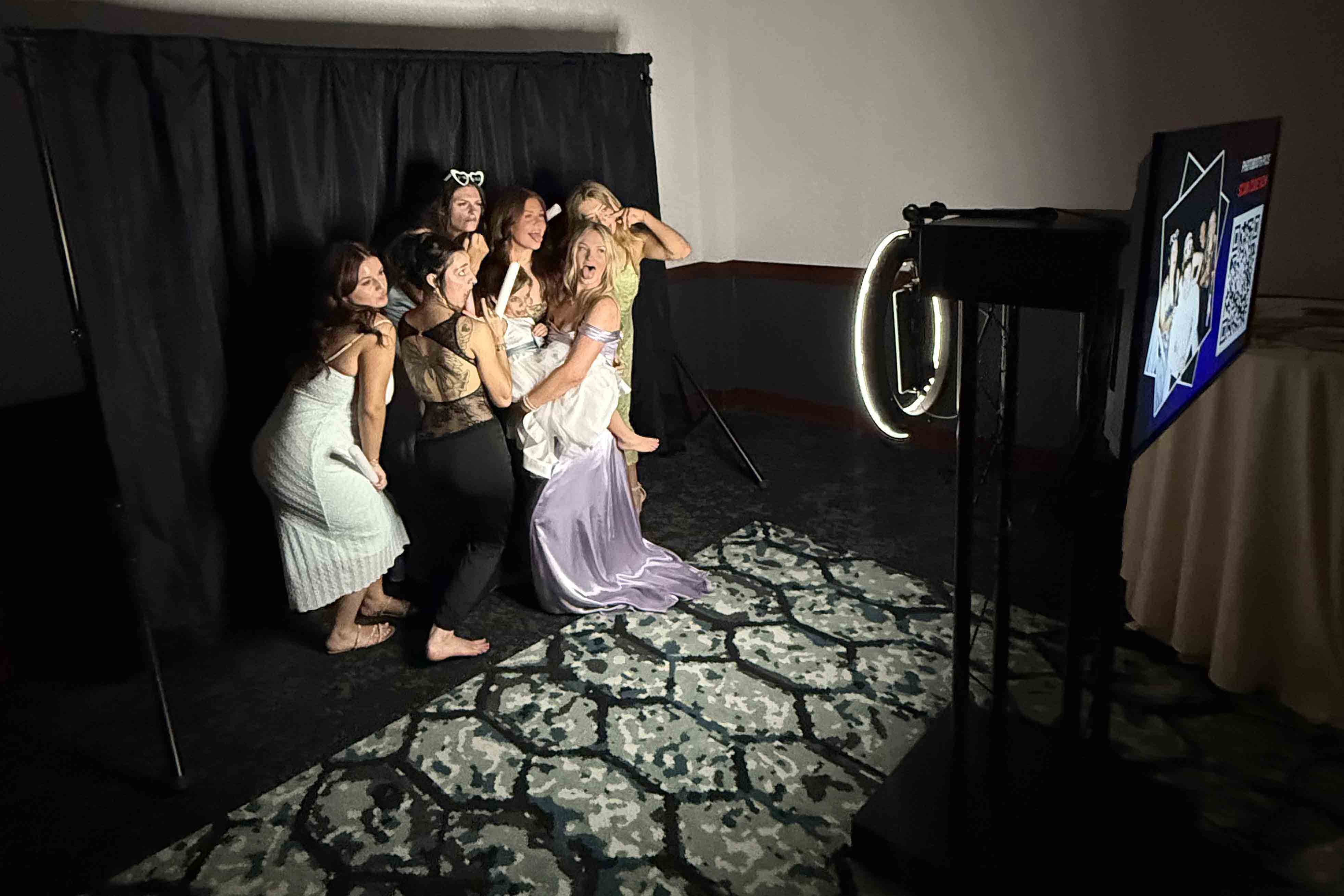 Wedding guests posing inside a traditional Ribalta photo booth with ring light and black backdrop during a live event photo booth experience